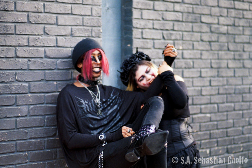 Two festival attendees, one dressed as a vampire drinking the other one's blood